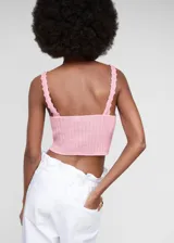 Top crop de punto color rosa, con cuello en V y tirantes finos. Tejido de algodón con detalle calado en el escote. Diseño entallado.