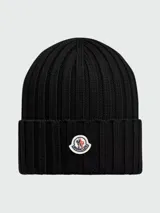 Gorro de lana tejido a punto acanalado, color bordó, con parche circular del logo de Moncler en el frente.