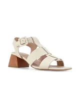 Sandalias de cuero color crema con tiras entretejidas, hebilla lateral y taco geométrico de madera.