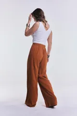 Pantalón camel de corte palazzo, con cintura alta con detalle de frunces y textura arrugada.