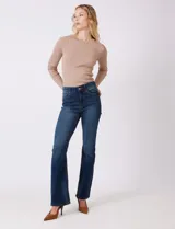 Jean elastizado de mezclilla azul oscuro, tiro alto, con pierna bootcut. Presenta costuras visibles y cinco bolsillos.