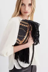 Cartera bandolera negra de cuero con diseño trenzado en el frente y flecos en gamuza. Tiene correa trenzada con terminación y forro de algodón.