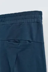 Bermuda azul petróleo de corte relaxed fit, confeccionada en algodón. Tiene cintura elástica ajustable con cordón, bolsillos laterales y un bolsillo trasero.