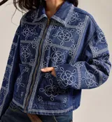 Campera de jean celeste con cierre frontal, cuello camisero, bolsillos con solapa y bordado de flores blancas.