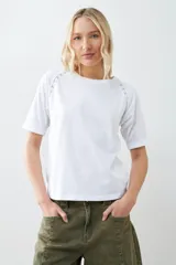 Remera color verde pistacho, de corte recto y manga corta raglán con detalle de vainillas en los hombros.