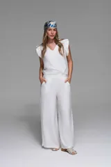 Pantalón palazzo blanco de crepé, con tiro medio-alto y cintura ancha.