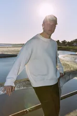 Sweater blanco de tejido plano, con cuello redondo, corte oversize y hombros caídos.