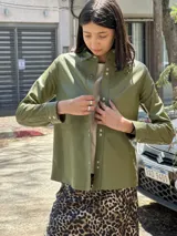 Camisa color beige confeccionada en cuero ovino. Corte recto con broches en el frente, cuello camisero y manga larga con puño.