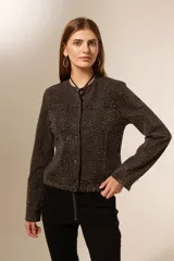 Campera de jean azul con apliques de strass plateados, corte clásico, con cuello redondo, bolsillos frontales y cierre con botones metálicos.