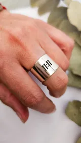 Anillo ancho de plata 925 con la inscripción "11:11" calada en el frente.