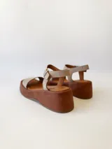 Sandalias con plataforma color beige, con tira ancha sobre los dedos y tira con hebilla al tobillo.