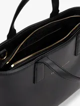 Cartera tote negra con textura granulada, doble asa corta y correa larga de tela con logo de la marca en blanco y negro.