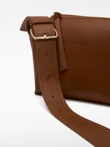 Bandolera pequeña de poliuretano color negro, con correa larga regulable con hebilla metálica y logo grabado.