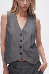 Chaleco gris sin mangas con cuello en V y cierre frontal con botones.