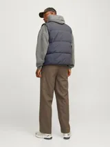 Chaleco puffer azul marino sin mangas con cuello alto y cierre de cremallera. Bolsillos frontales y relleno de fibra sintética.