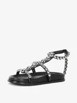 Sandalias blancas con tachas plateadas, forro y suela sintética, con cierre de velcro.