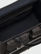 Bolso tote mediano de lona color beige con detalles en negro. Tiene doble asa de mano de cuero y correa bandolera ajustable y extraíble. Cuenta con dos bolsillos frontales con solapa y un bolsillo frontal con cierre. Estampado frontal con la leyenda "THE TOTE BAG" y el logo "MARC JACOBS".