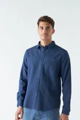 Camisa marrón de manga larga con bolsillo en el pecho y cierre con botones.