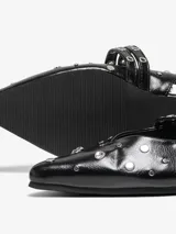Ballerinas negras de cuero sintético con punta fina, tira ajustable con hebilla y apliques de tachas plateadas.
