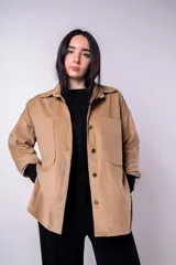 Sobrecamisa color beige de pana con cuello camisero, cierre frontal con botones a presión, dos bolsillos de parche en el pecho y corte holgado.