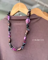 Conjunto de collares de cuentas de diferentes colores y materiales, incluyendo cuentas de piedra, madera y cristal. Los collares tienen cadenas doradas y etiquetas blancas con la marca "MANDRA".
