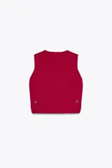 Top chaleco de punto color fucsia, con cuello redondo y sisas amplias. Presenta botones dorados decorativos en los laterales.