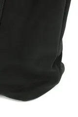 Bolso shopper negro con tachas plateadas en los laterales y en las asas. Tiene un bolsillo interno.