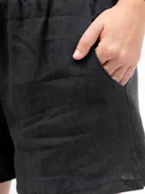 Shorts negros de lino con cintura elástica y dos bolsillos laterales.