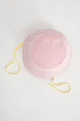 Gorro tipo bucket de color rosa con cordones amarillos y bordado de margarita blanca en el frente.