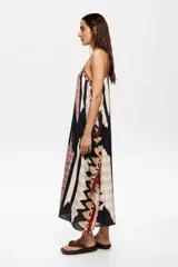 Vestido largo con estampado geométrico en tonos blanco, negro, rojo y marrón. Tiene tirantes finos y corte holgado.