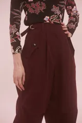 Pantalón de tiro alto color borgoña, con presillas en la cintura, bolsillos laterales con tapa y pinzas a la altura de la rodilla.