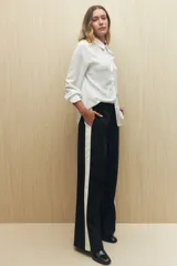 Pantalón de jogging color crema con cintura elástica, cordón ajustable y franja lateral negra.