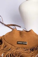 Bandolera marrón de gamuza con flecos largos y correa fina ajustable.