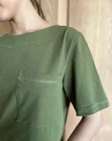 Remera negra con cuello redondo y mangas cortas, con detalle de pespuntes blancos en cuello, mangas, bolsillos frontales y ruedo.