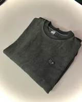 Buzo verde con efecto nevado, corte oversized y cuello redondo.