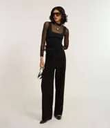 Pantalón de vestir negro de corte sastrero, confeccionado en poliéster, viscosa y elastano. Presenta cintura ancha con cintos laterales ajustables.