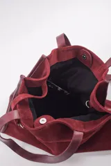Bolso tipo shopper de cuero color bordó, con doble asa de hombro y cierre magnético. Incluye un amplio bolsillo interior con cierre de cremallera.