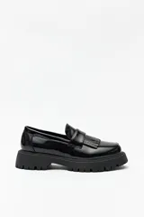 Mocasines negros chunky de símil cuero, con plataforma de 4cm de alto y detalle de flecos.