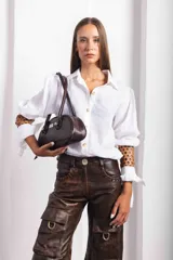 Cartera baguette negra con textura símil cuero de reptil, doble asa corta y logo metálico plateado de la marca Agnes.