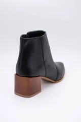 Bota corta plateada de cuero, con punta fina y taco de madera.