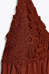 Vestido midi color ladrillo con tirantes finos, escote en pico y detalle de encaje en el busto. Tejido plisado y bajo asimétrico.