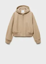 Chaqueta con capucha color beige, con cierre frontal de cremallera, cuello alto, puños elásticos y diseño oversize.