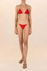Top de bikini triángulo rojo con ribetes color crema, confeccionado en lycra texturizada y con copas removibles.