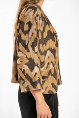 Kimono con estampado abstracto en tonos marrón, beige y negro. Tiene mangas 3/4 y bolsillos laterales.