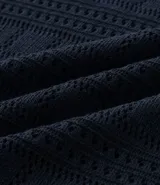 Remera polo de hombre color beige, con cuello en V, mangas cortas y textura patchwork calada.