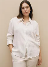 Camisa celeste con rayas verticales finas, de tejido fluido, manga larga abotonada, cuello camisero y corte recto.