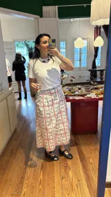 Falda midi blanca con lunares amarillos y bolsillos laterales.