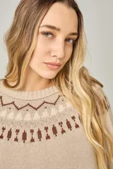 Sweater tejido color verde agua con cuello redondo y diseño de ochos con detalles rosados en la parte superior.