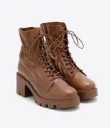 Bota de cuero color marrón con cordones, caña media con detalle de elástico en la parte trasera, taco bloque medio y suela track.