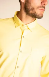 Camisa amarilla de algodón orgánico, manga larga con botones de madera, cuello italiano, calce regular, bolsillo de pecho con logo bordado.